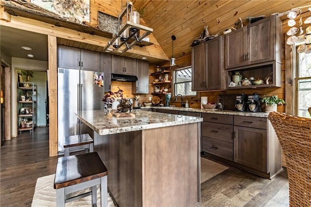 185 SW 51st Rd, Warrensburg, MO 64093 - kitchen featuring open shelves, high quality fridge, under cabinet range hood, dark wood-style floors, and a breakfast bar area