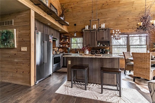 185 SW 51st Rd, Warrensburg, MO 64093 - kitchen with appliances with stainless steel finishes, open shelves, wood walls, dark wood-type flooring, and a sink