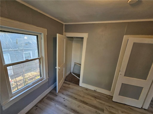 4410 Myrtle Ave, Kansas City, MO 64130 - unfurnished bedroom with baseboards, crown molding, and light wood-type flooring