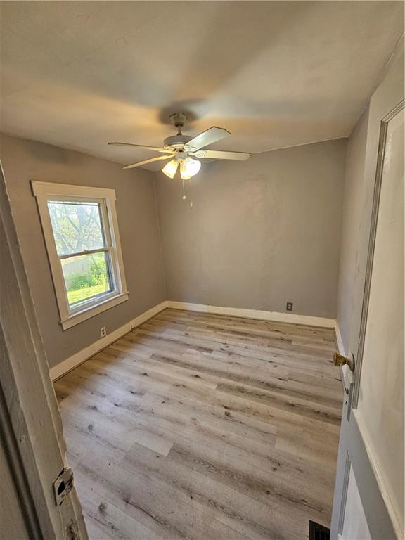 4410 Myrtle Ave, Kansas City, MO 64130 - spare room featuring baseboards, a ceiling fan, wood finished floors, and visible vents