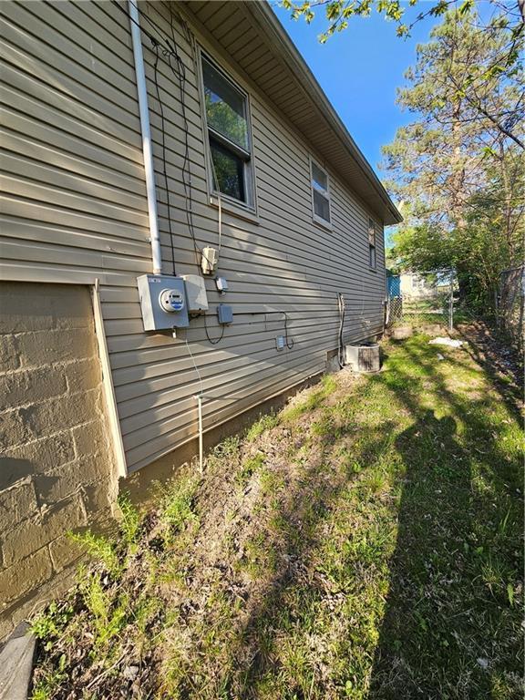 4410 Myrtle Ave, Kansas City, MO 64130 - view of side of home with fence and a yard