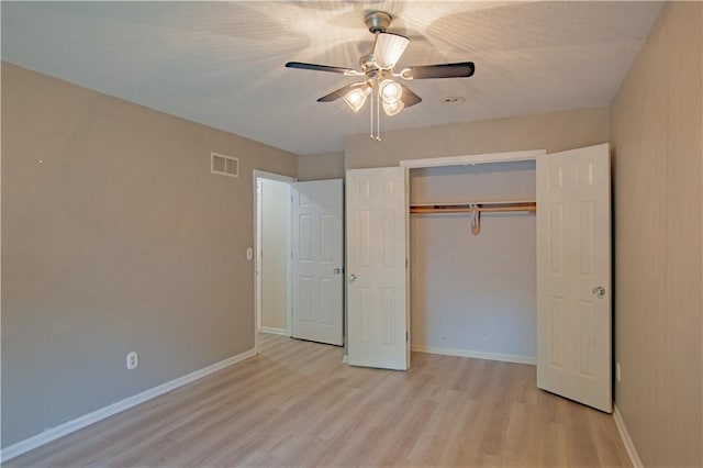 unfurnished bedroom featuring light wood finished floors, a closet, baseboards, and a ceiling fan