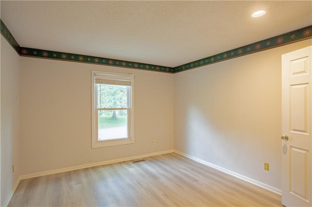 unfurnished room with wood finished floors, baseboards, and recessed lighting