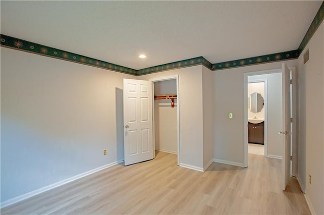 unfurnished bedroom featuring light wood finished floors, baseboards, recessed lighting, and a closet