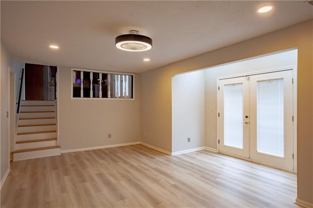 unfurnished room with french doors, light wood-style flooring, recessed lighting, baseboards, and stairway