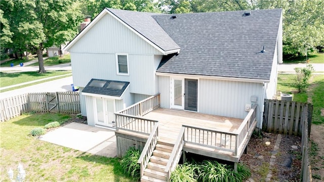 rear view of property with roof with shingles, a wooden deck, a chimney, and stairs