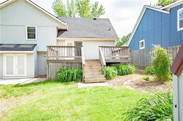 rear view of property featuring a shingled roof and a deck