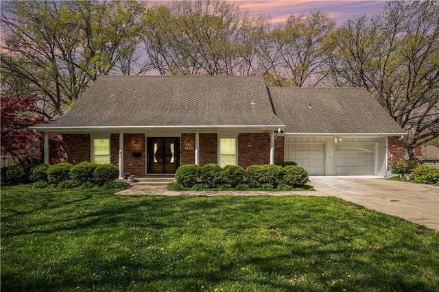 10100 El Monte St, Overland Park, KS 66207 - ranch-style house with an attached garage, concrete driveway, a front lawn, and brick siding