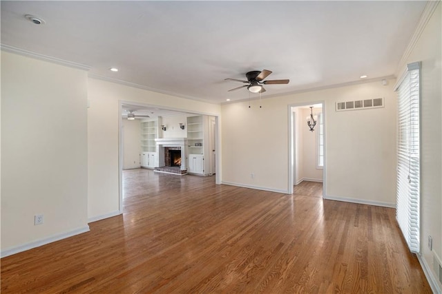 10100 El Monte St, Overland Park, KS 66207 - unfurnished living room with crown molding, ceiling fan, visible vents, and a wealth of natural light
