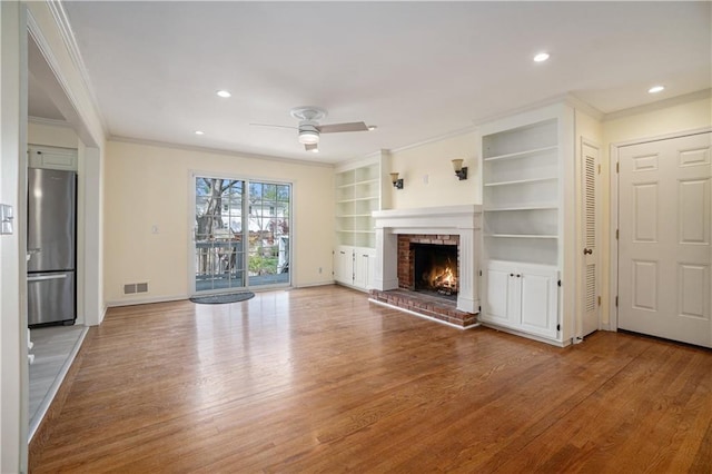 10100 El Monte St, Overland Park, KS 66207 - unfurnished living room with crown molding, a ceiling fan, wood finished floors, and a fireplace