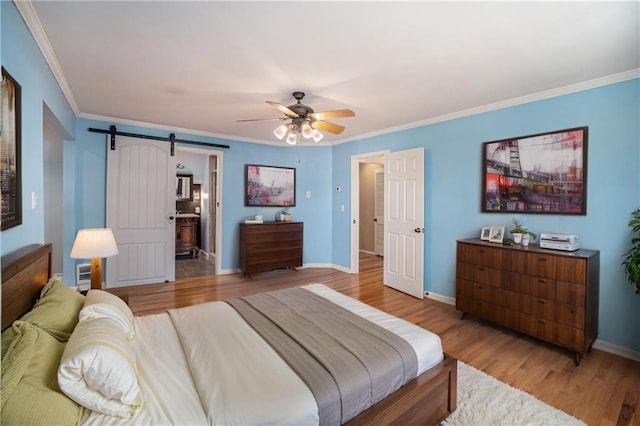 10100 El Monte St, Overland Park, KS 66207 - bedroom with crown molding, baseboards, a barn door, and light wood-type flooring