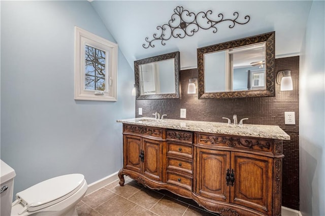 10100 El Monte St, Overland Park, KS 66207 - full bathroom with tile patterned flooring, double vanity, toilet, baseboards, and vaulted ceiling