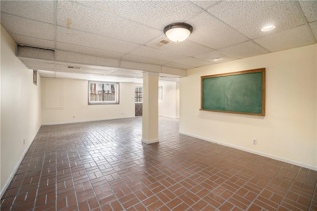 10100 El Monte St, Overland Park, KS 66207 - below grade area with baseboards, brick floor, a drop ceiling, and visible vents