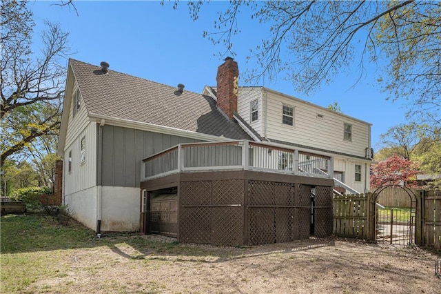 10100 El Monte St, Overland Park, KS 66207 - back of property with fence, a shingled roof, a deck, a gate, and a chimney