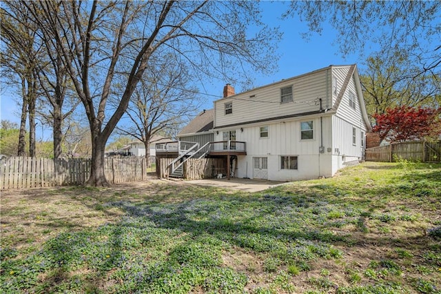 10100 El Monte St, Overland Park, KS 66207 - back of house with a chimney, a lawn, a deck, stairway, and a fenced backyard
