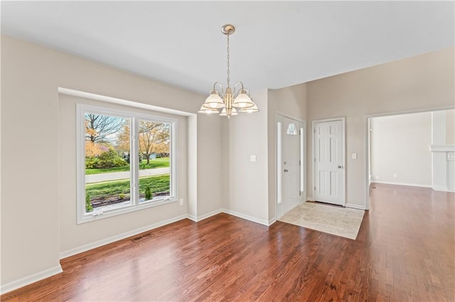 1010 SW Cross Creek Dr, Grain Valley, MO 64029 - unfurnished dining area featuring baseboards, wood finished floors, a chandelier, and visible vents