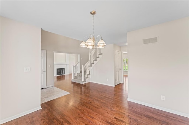 1010 SW Cross Creek Dr, Grain Valley, MO 64029 - unfurnished dining area with stairway, wood finished floors, visible vents, baseboards, and a chandelier