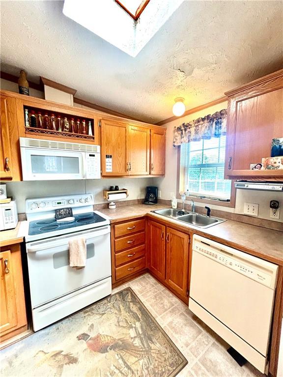 171 E 5th St, Schell City, MO 64783 - kitchen with a sink, a textured ceiling, white appliances, brown cabinets, and light countertops