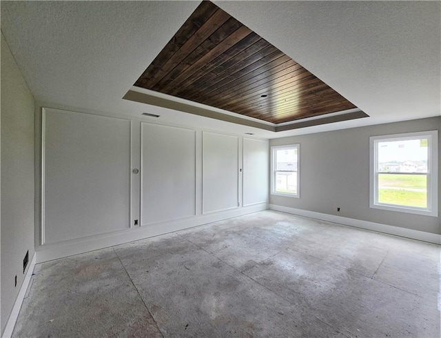 2615 SW Firefly Ln, Lees Summit, MO 64082 - unfurnished room with a tray ceiling, wooden ceiling, concrete floors, and baseboards