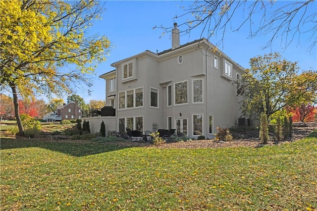 11250 W 191st St, Overland Park, KS 66083 - back of house featuring a chimney, stucco siding, and a lawn