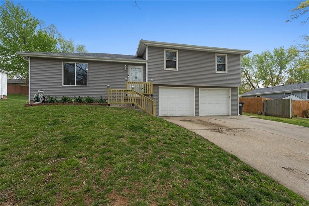 402 Hithergreen Dr, Lansing, KS 66043 - tri-level home featuring fence, concrete driveway, a front lawn, and a garage