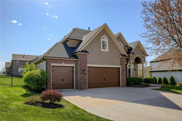 9500 N Lane Ave, Kansas City, MO 64157 - view of front of property featuring fence, a front lawn, brick siding, stucco siding, and concrete driveway