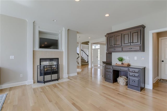 9500 N Lane Ave, Kansas City, MO 64157 - bar with light wood-style floors, a tiled fireplace, stairs, recessed lighting, and baseboards