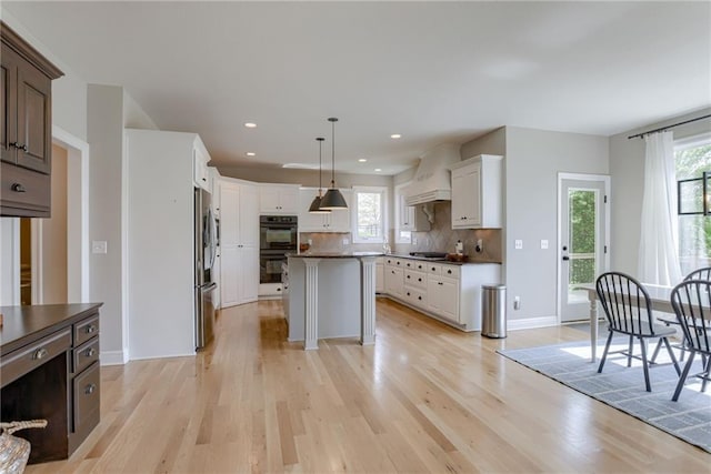 9500 N Lane Ave, Kansas City, MO 64157 - kitchen with dobule oven black, backsplash, stainless steel refrigerator with ice dispenser, dark countertops, and light wood-style flooring
