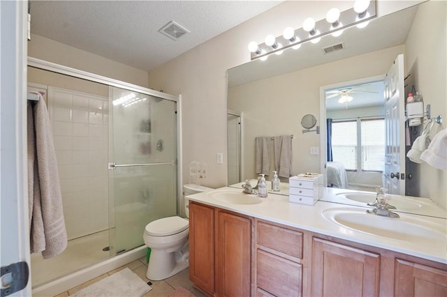bathroom with a sink, double vanity, visible vents, a shower stall, and ceiling fan