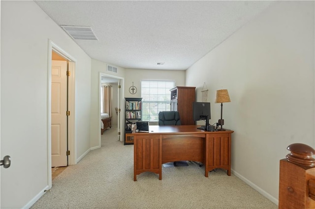 office with light carpet, a textured ceiling, and visible vents