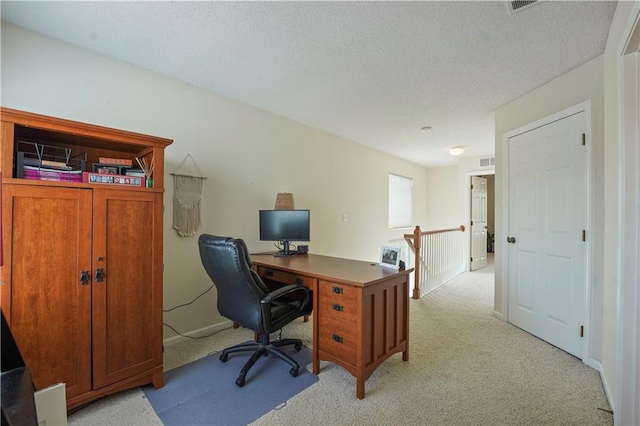 office featuring light colored carpet, a textured ceiling, and visible vents