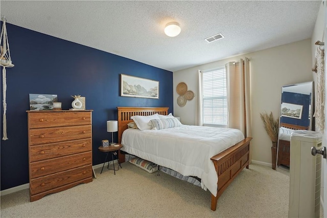 carpeted bedroom with baseboards, a textured ceiling, and visible vents