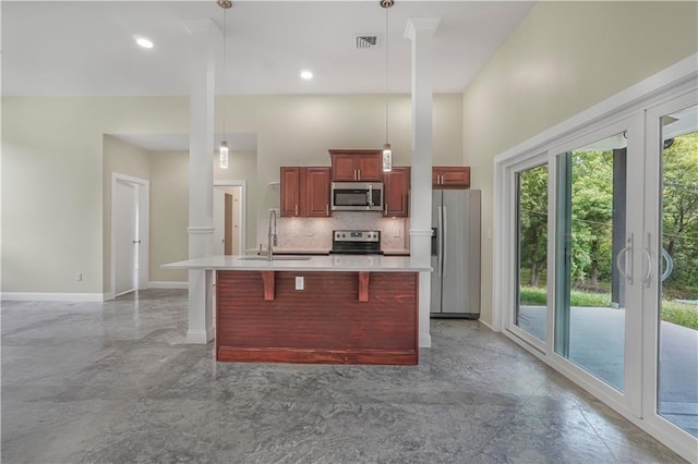 kitchen featuring stainless steel appliances, light countertops, a sink, and hanging light fixtures