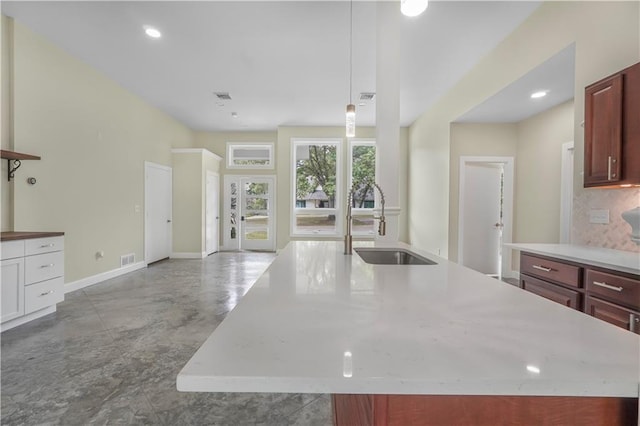 kitchen with a sink, visible vents, baseboards, concrete flooring, and light countertops