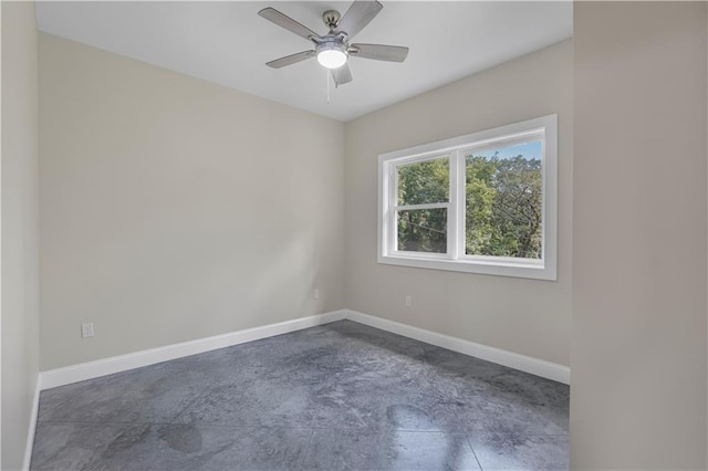 unfurnished room with concrete flooring, baseboards, and ceiling fan