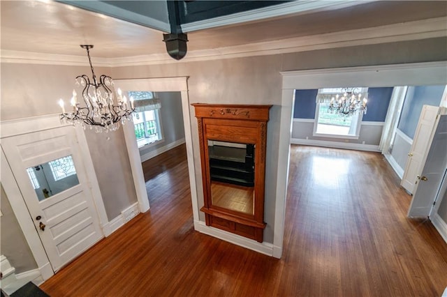603 N 5th St, Atchison, KS 66002 - unfurnished living room with a chandelier, dark wood-style floors, crown molding, and baseboards