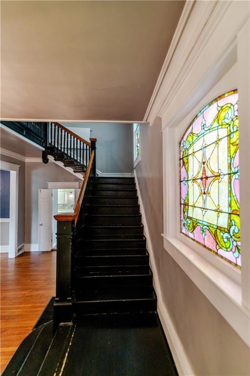 603 N 5th St, Atchison, KS 66002 - staircase featuring wood finished floors, baseboards, and crown molding