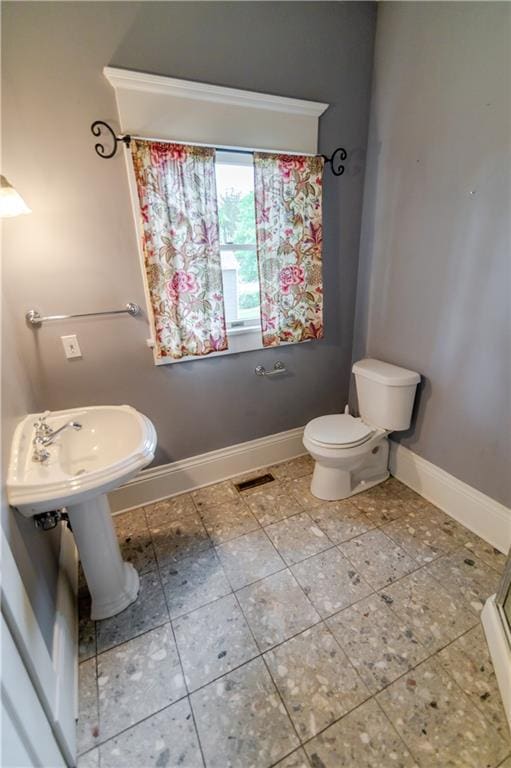 603 N 5th St, Atchison, KS 66002 - bathroom featuring baseboards and toilet