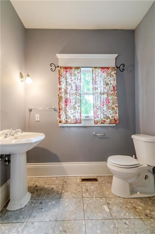 603 N 5th St, Atchison, KS 66002 - half bathroom featuring baseboards, toilet, and a sink