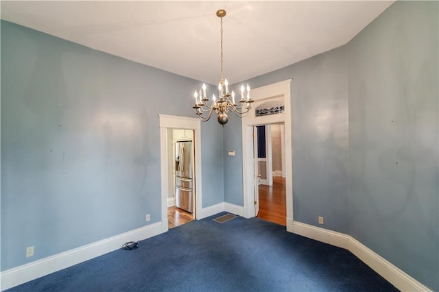 603 N 5th St, Atchison, KS 66002 - spare room featuring a chandelier, carpet, and baseboards