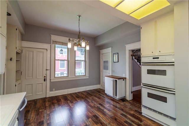 603 N 5th St, Atchison, KS 66002 - kitchen featuring double oven, dark wood-style flooring, hanging light fixtures, light countertops, and a chandelier