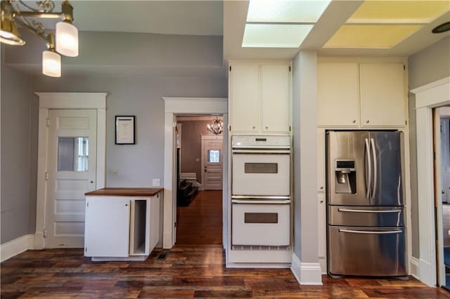 603 N 5th St, Atchison, KS 66002 - kitchen with stainless steel fridge with ice dispenser, double oven, a chandelier, and dark wood-style flooring