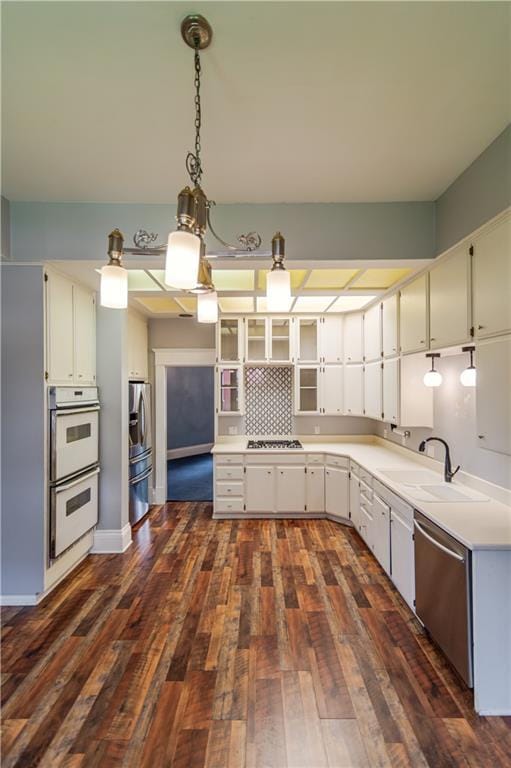 603 N 5th St, Atchison, KS 66002 - kitchen with stainless steel appliances, a sink, dark wood-style floors, light countertops, and white cabinetry