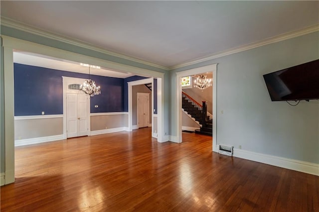 603 N 5th St, Atchison, KS 66002 - unfurnished living room featuring a chandelier, stairs, wood finished floors, ornamental molding, and baseboards