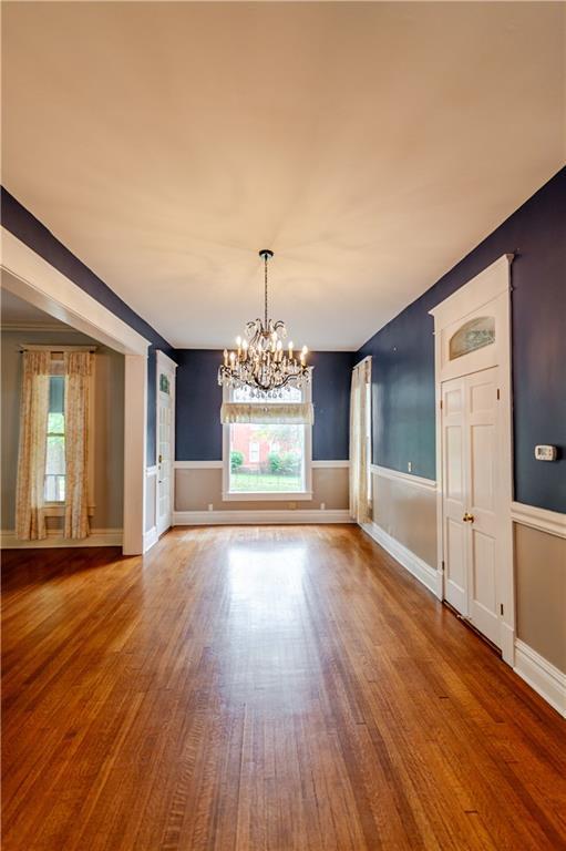 603 N 5th St, Atchison, KS 66002 - unfurnished dining area featuring a chandelier, wood finished floors, and wainscoting