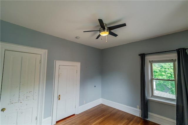 603 N 5th St, Atchison, KS 66002 - unfurnished bedroom featuring baseboards, wood finished floors, and a ceiling fan