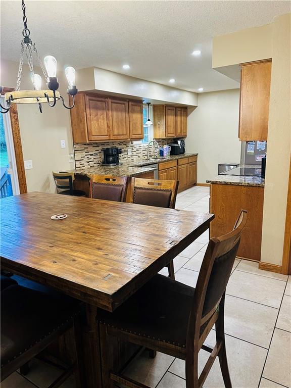 dining area featuring light tile patterned flooring, a textured ceiling, a chandelier, and recessed lighting