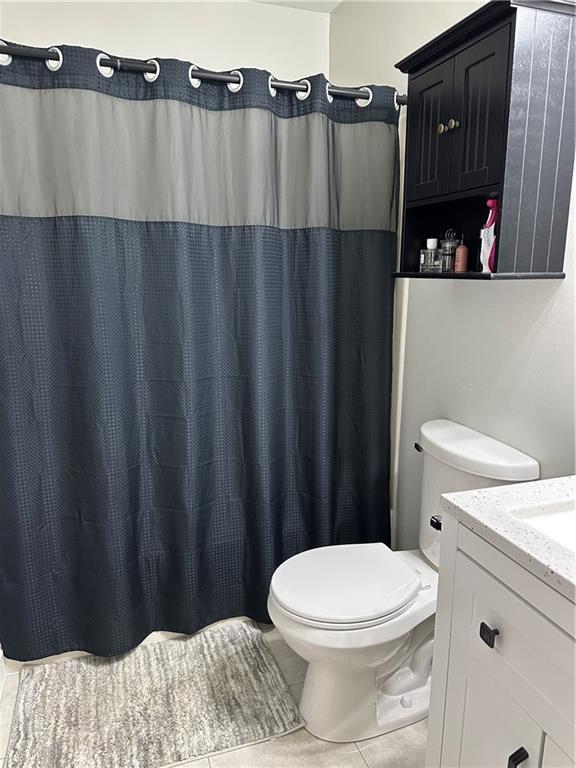 full bath featuring toilet, tile patterned floors, and vanity