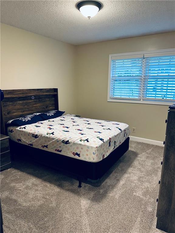 bedroom with carpet flooring and a textured ceiling