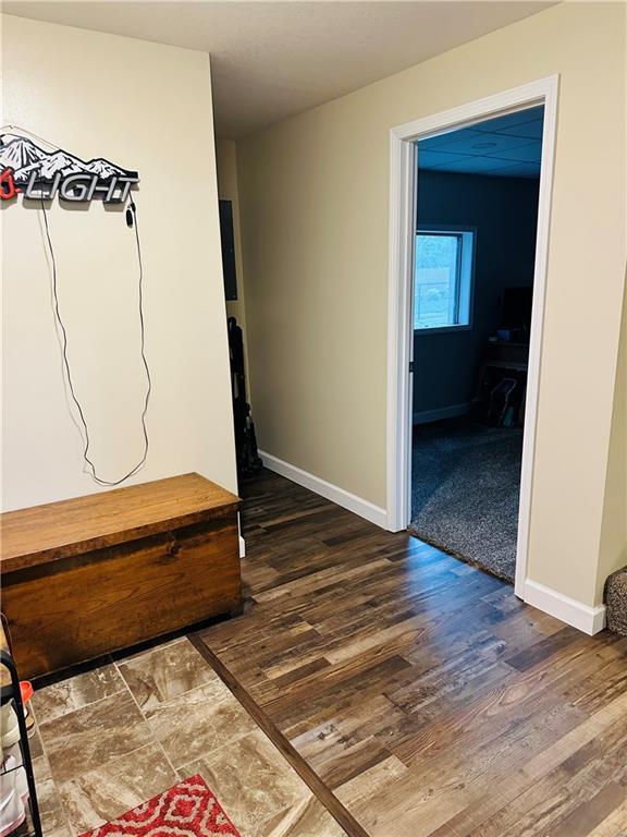 hall with baseboards and dark wood-style floors